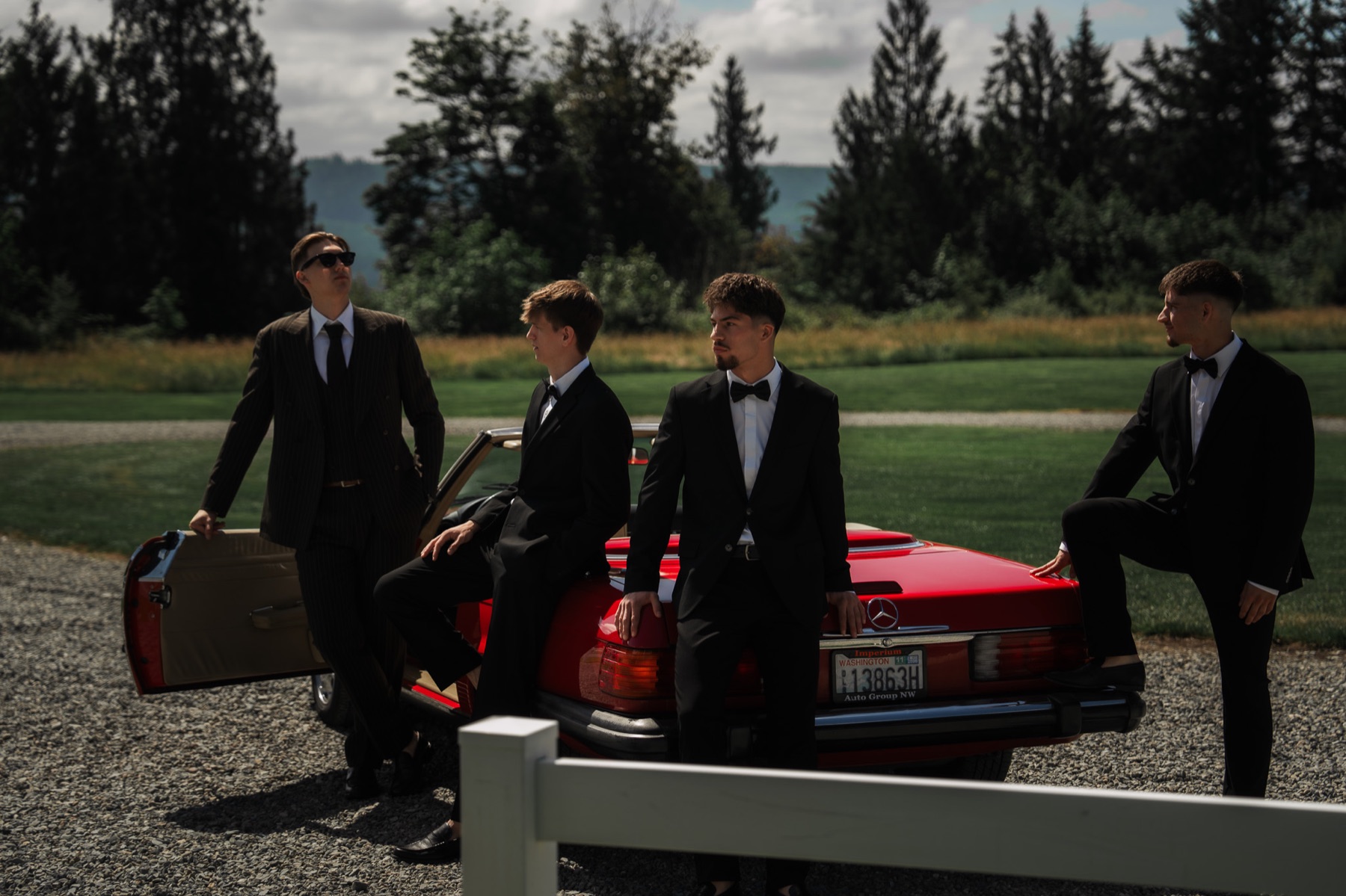Wedding party beside a red classic convertible
