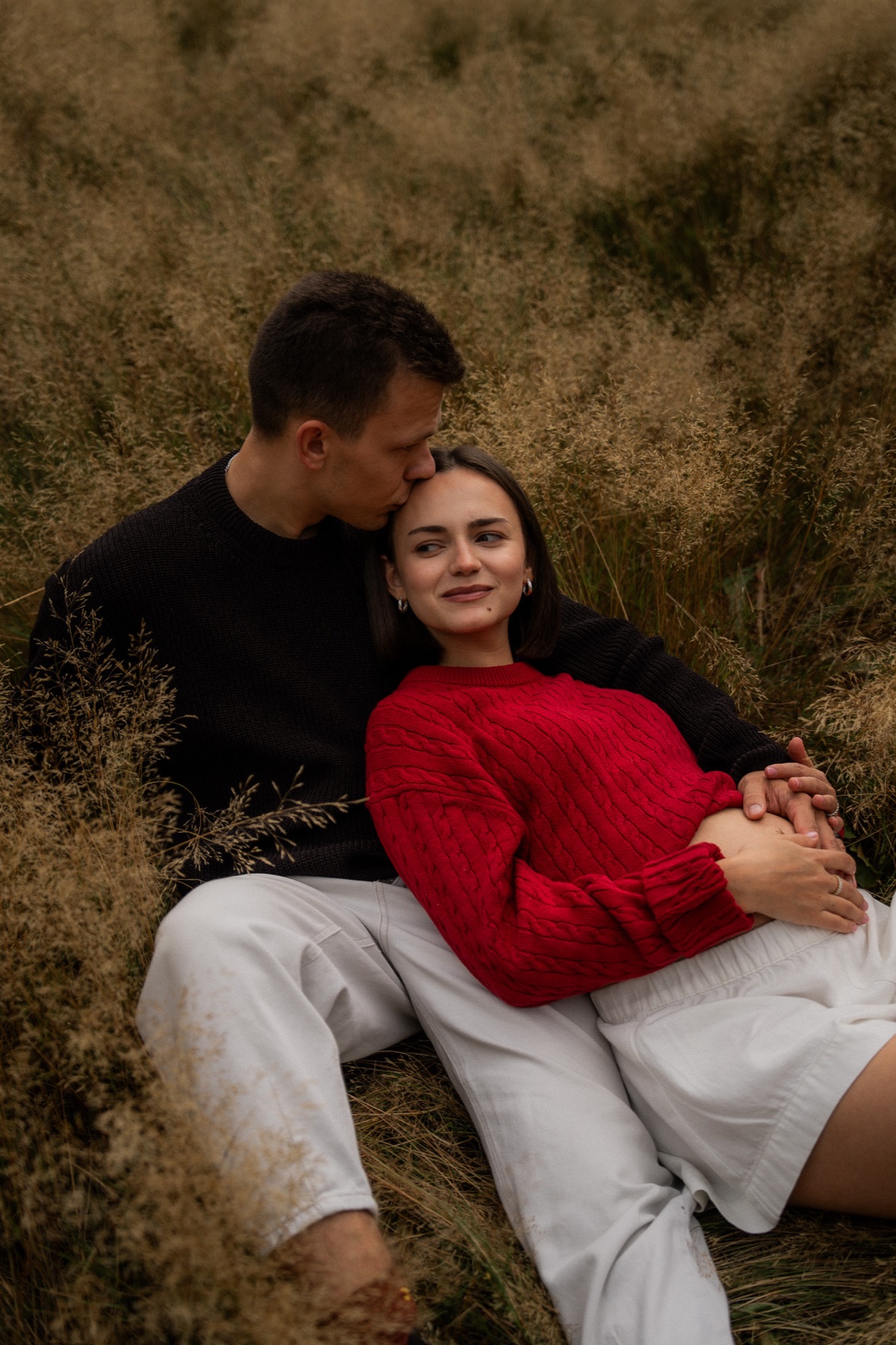 Expecting couple embracing in a field